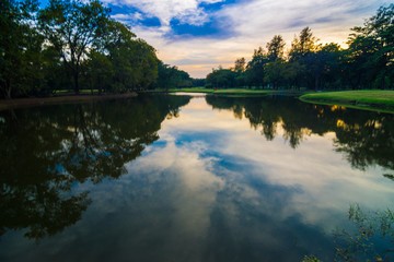 Fototapeta na wymiar Public park with pond sunset beautiful sky in evening