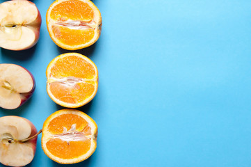 Oranges and apples on blue background