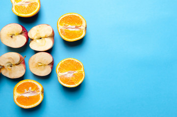 Fototapeta na wymiar Oranges and apples on blue background