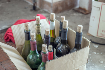 Staubige Weinflaschen im Pappkarton
