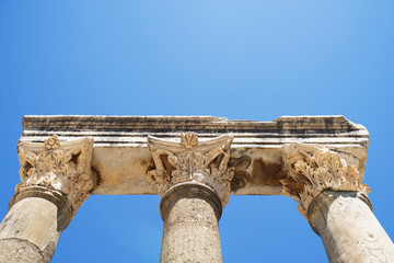 Ionic column capital with scrolling volutes and blue sky.doric c