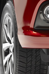 Red car body and alloy wheels detail.