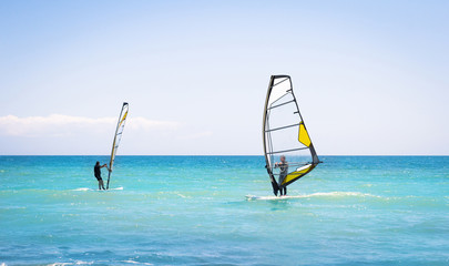 Windsurfing sails on the blue sea