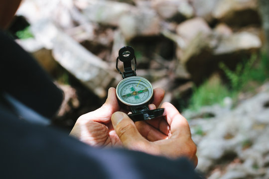 Man Using a Compass in a Nature Scenery