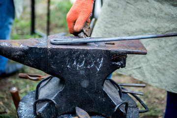 blacksmith works on an anvil.