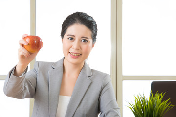 Young asian businesswoman eating healthy snack, apple