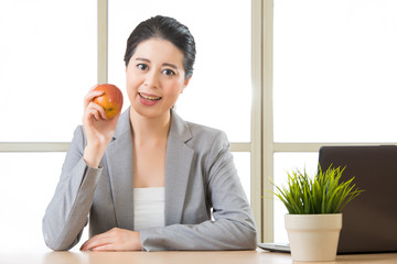 Young asian businesswoman eating healthy snack, apple