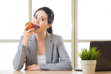 Young asian businesswoman eating healthy snack, apple