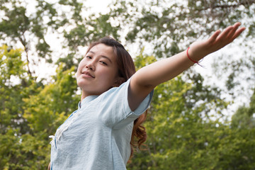 Asian girl with open arms to enjoy nature