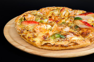 Seafood pizza on a wooden tray.