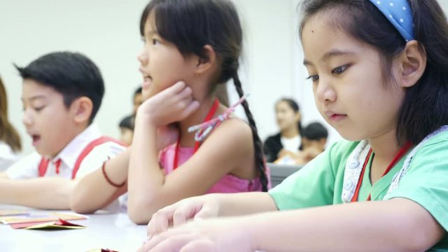 4K : Asian child learning to folding Japanese paper origami, art of paper folding