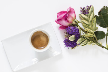 la tazzina del caffè,con vicino il mazzo di fiori ,su sfondo bianco