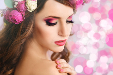 Fototapeta premium Beautiful young woman wearing floral headband on festive background