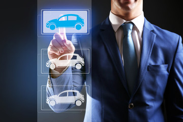 Businessman touching icon of car on virtual screen