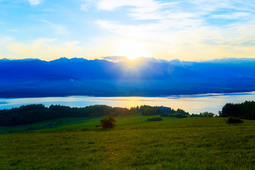 Beautiful landscape, green meadow and lake with mountain in background. Slovakia, Central Europe.