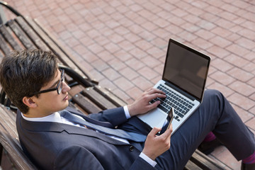 Man using laptop and smartphone