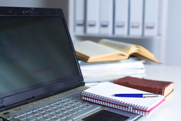 desktop in the office with a laptop and notebooks