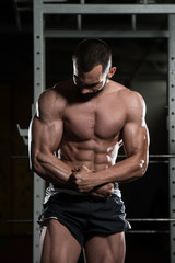 Fototapeta na wymiar Muscular Man Flexing Muscles