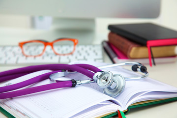 Stethoscope lying on a table on an open book