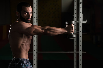 Fototapeta na wymiar Shoulders With Dumbbells Exercise In A Gym