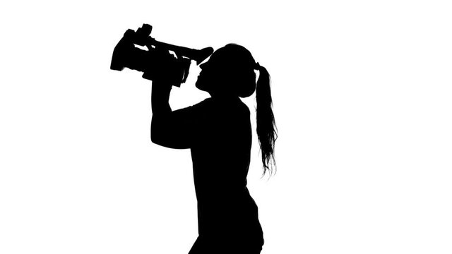 Girl shoots video or movie. White. Silhouette