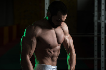 Fototapeta na wymiar Young Bodybuilder Flexing Muscles