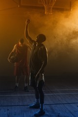 Victorious basketball player raising his arms up