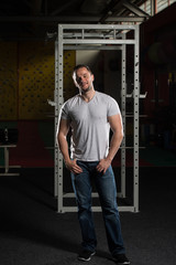 Fototapeta na wymiar Man In Jeans Standing In A Dark Gym