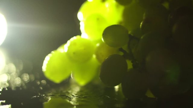 Green grape on a platter with a beautiful light on black background loop video