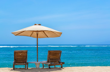 Sun lounger on tropical beach with a umbrella looking out to the horizon on a perfect sunny day in Bali