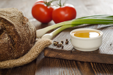 Bread with tomatos, onion, oil and pepper on wooden table