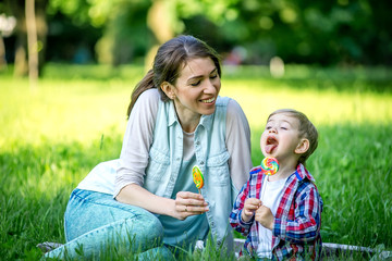 Mother with baby in the park eating sweets.