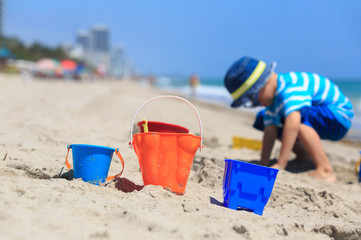 little boy play with sand on beach