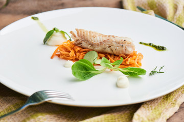 Dinner of Pollock in the marinade, served on a white plate