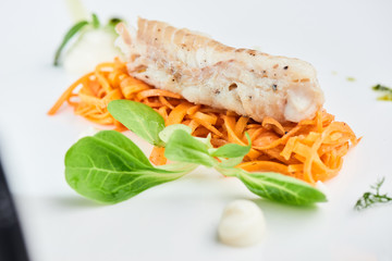 Dinner of Pollock in the marinade, served on a white plate