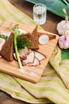 Appetizer to vodka of smoked bacon and black bread served on a wooden Board