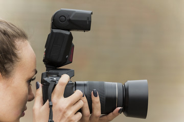 girl with beautiful manicure photographs on single-lens reflex camera