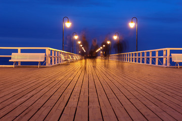 wooden pier at night, long exposure, people blurred