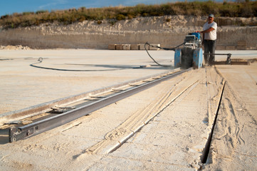 Tufa stone quarry: close up view of just cut tufa stone and a sawing machine in the background