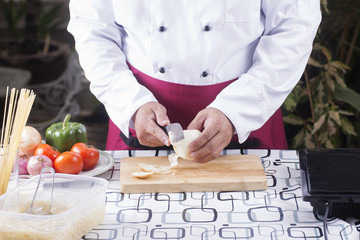 Chef peeling onion with knife