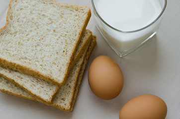 Sliced Whole Wheat Bread, Boiled Egg and Milk for Breakfast.