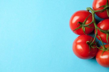 Five fresh tomatoes on a blue background from above with text sp