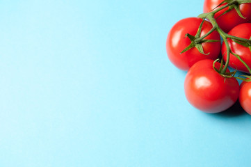 Five fresh tomatoes on a blue background from above with text sp