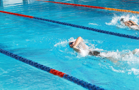 woman swimming competition, forward crawl, rear side view