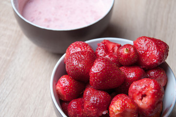 Strawberries and strawberries with cream in bowl on wooden table