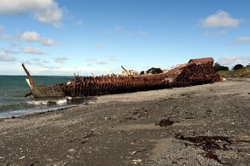 Rusty ship on the shore of the Strait of Magellan in the village of San Gregorio.