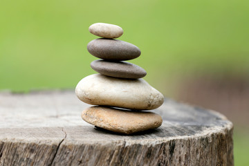 Balance Stones stacked to pyramid in the soft green background.