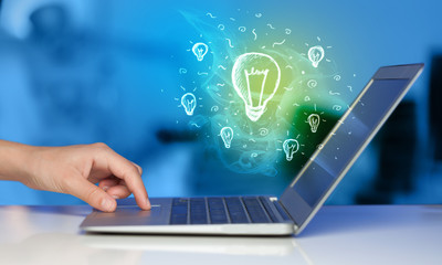 Close up of hand with laptop and  idea bulb