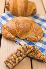fresh pastries on a wooden background. blue napkin. croissant