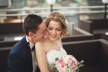 Happy wedding couple, bride, groom kissing with view of old city